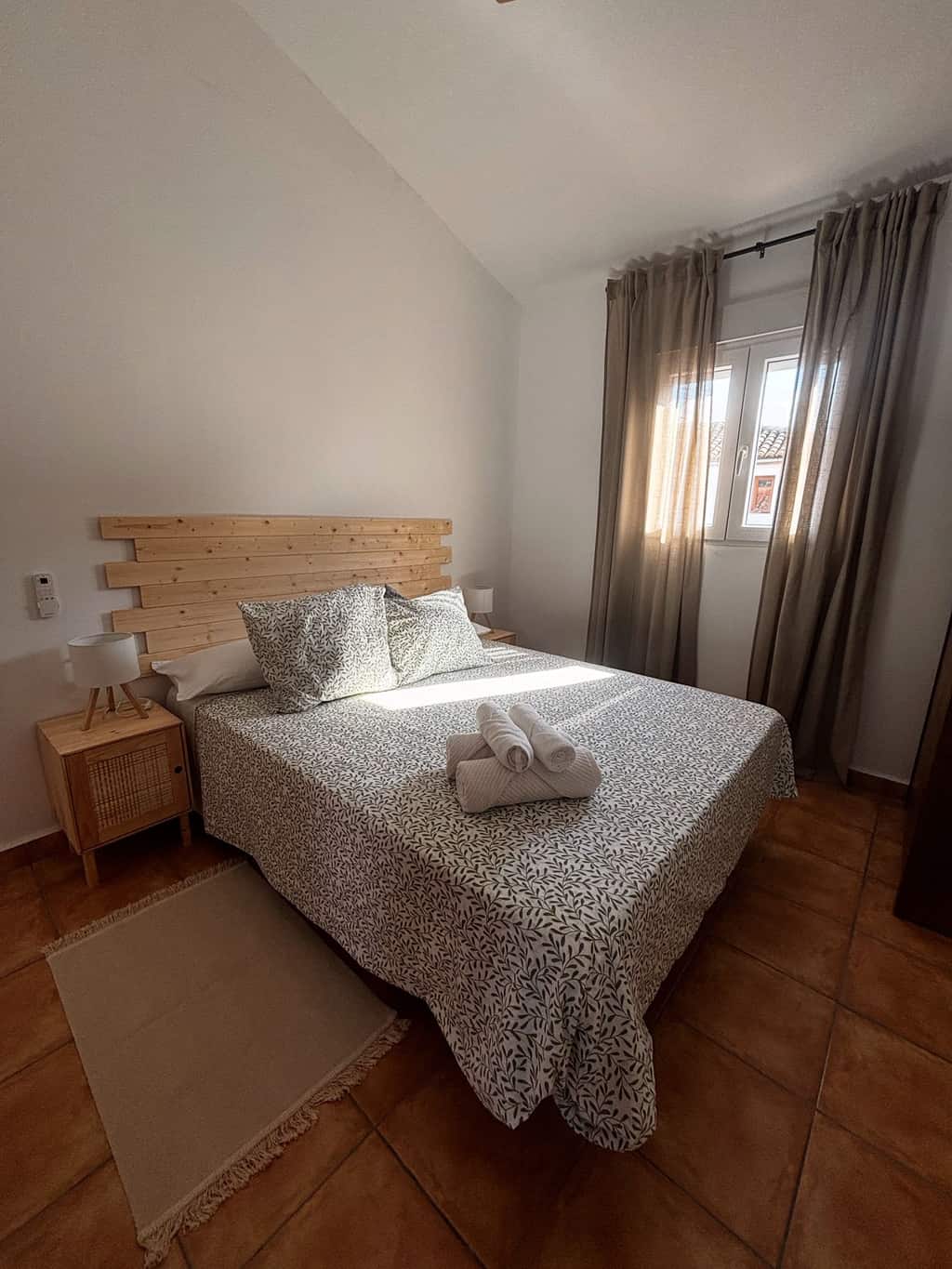 Dormitorio principal preparado con ropa de cama y toallas